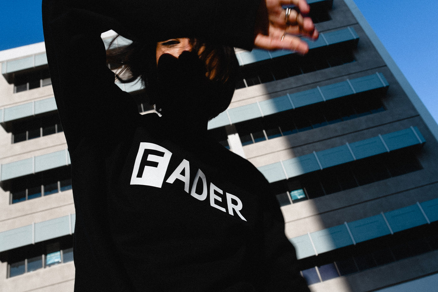 woman wearing black long sleeve with the FADER logo