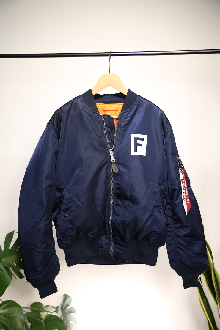 FADER x Alpha MA navy flight jacket with FADER F block on pocket  on hanger