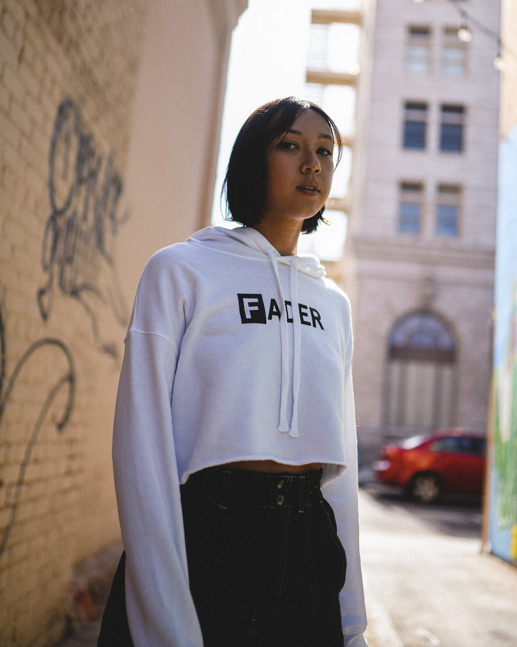 woman wearing white crop hoodie with the FADER logo
