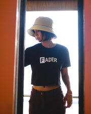woman wearing black crop tee with the FADER logo